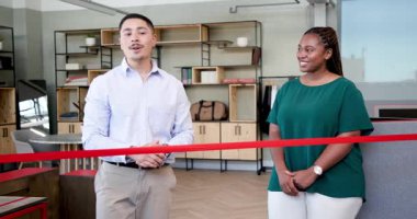 Afro-Amerikalı kadın ve çeşitli adam modern ofis içinde kırmızı kurdeleyi makasla kesiyor. Kutlama, takım çalışması, başarı, başarı, girişimcilik, etkinlik, ofis