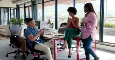 Çeşitli iş arkadaşları ofiste kontratı kutluyor, dizüstü bilgisayar kullanıyor ve kağıt tutuyor. Kutlama, takım çalışması, başarı, motivasyon, neşe, işbirliği, başarı