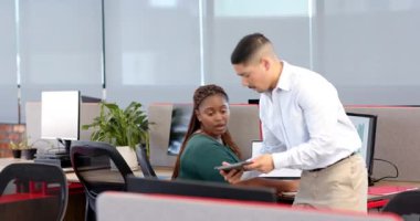 Çeşitli iş arkadaşları modern ofiste fikir alışverişinde bulunurken, tablet ve monitörler kullanılıyor. İşbirliği, teknoloji, üretkenlik, beyin fırtınası, işyeri, modern, odaklanma