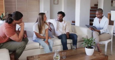 Bir grup arkadaş sıcak oturma odasındaki kanepede düşünceli bir şekilde tartışıyorlar. sohbet, gündelik, çok kültürlü, etkileşim, birliktelik, kapalı alan