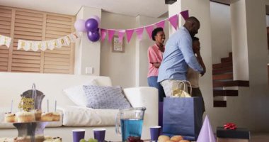 Aile evde doğum gününü kutluyor, aileler gülümsüyor, çocuk heyecanla hediyeleri açıyor. Kutlama, mutluluk, çocukluk, duygular, mevcut, neşeli