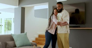 Gri kanepede pembe hediye kutusu ve beyaz çiçeklerle çeşitli çiftler kutlama yapıyor. Kutlama, romantizm, samimiyet, neşe, birliktelik, hediyeler, yaşam tarzı