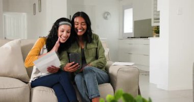 Anne ve genç kız, akıllı telefon okuyup gösterirken kanepede iyi haber mektubu açıyorlar. Aile, iletişim, bağlantı, mutluluk, modern yaşam tarzı, sıcaklık