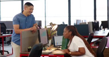 Çeşitli iş arkadaşları, açık yeşil çanta ve dostça gülümsemeyle modern ofiste başarıyı kutluyorlar. Meslektaşlar, kutlamalar, takım çalışması, işbirliği, modern çalışma alanı, pozitiflik