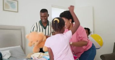 Aile, dağınık giysiler ve çamaşır sepetiyle yıkanmamış yatağın üzerine çamaşır katlıyor. Aile içi, takım çalışması, organizasyon, ebeveynlik, uyum, konfor, yaşam tarzı, angarya