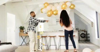 Çeşitli çiftler mutfağa giriyor yıldönümü balonları düzenliyor, şampanya dolduruyor ve kadeh kaldırıyor. Romantizm, kutlama, yakınlık, dekor, neşeli, evcil, modern