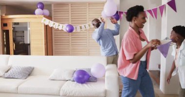 Baba ve oğul doğum günü kutlaması sırasında evde balonlarla oynuyorlar. Aile, bağ, neşe, birliktelik, ev eğlencesi, babalık.