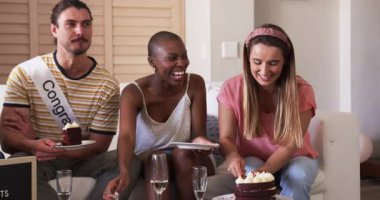 Arkadaşlar evde pasta ve sohbetin tadını çıkarıyorlar, gülücükler ve kahkahalarla kutluyorlar. Kutlama, arkadaşlık, mutluluk, tatlı, sosyalleşme, toplanma