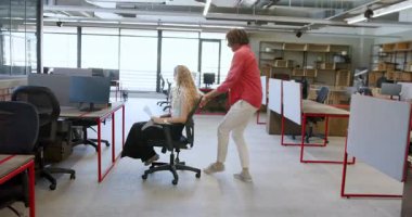 Genç adam modern ofis alanından uzaklaşıyor, kurdele kesme törenini enerjiyle kutluyor. Kutlama, takım çalışması, başarı, şirket, modern, parlak, çalışma alanı