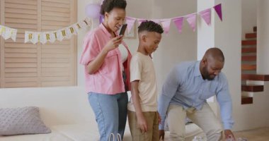 Balonlar ve dekorasyonlarla evde neşeyle dans eden aile. parti, mutluluk