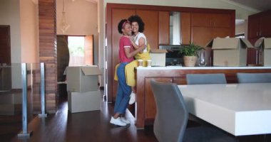 Mutfakta kucaklaşan çeşitli kadın çiftler evlerinde taşınan kutular ve kahve fincanlarıyla çevrili. Taşınma, boşaltma, aşk, neşeli, aile içi, birliktelik