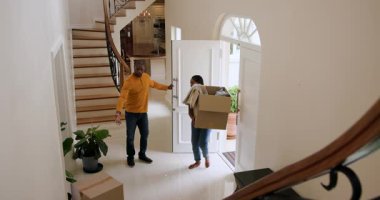 Mutlu siyah kadın ve erkek, karton kutuları ön kapıdan taşıyıp güneşli bir günde yeni bir eve taşınıyorlar. Yeni ev, mülk, mutluluk, yaşam tarzı ve ilişki kavramı.