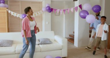 Evde balonlarla kutlama yapan aileler, oğluyla oynayan Afrikalı Amerikalı aileler. Kutlama, mutluluk, bağlılık, ebeveynlik, şenlik, keyif