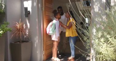 Afro-Amerikan ailesi okula giriş gününde pembe sırt çantası ve kurye çantası taşıyarak başlıyor. Aile, eğitim, giriş, birliktelik, modern, hazırlık, yaşam tarzı, parlak, besleyici