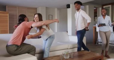 Arkadaşlar modern oturma odasında birbirlerini sıcak bir şekilde selamlıyorlar, neşeli anları paylaşıyorlar. Arkadaşlık, toplanma, mutluluk, yaşam tarzı, bağlanma, kutlama