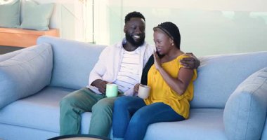 Afro-Amerikalı çift evdeki kanepede oturuyor, onun jesti onu kahkahalarla güldürüyor bardakları kızartıyordu. Romantizm, samimiyet, arkadaşlık, rahatlama, konfor, yaşam tarzı, modern