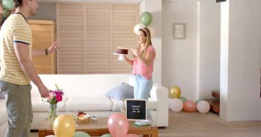 Yeni işi kutluyoruz, arkadaşlar oturma odasındaki partide pasta ve balonların tadını çıkarıyorlar. Kutlama, dostluk, mutluluk, toplanma, tebrikler, ev