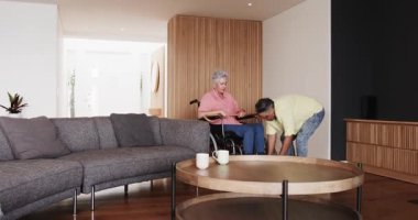 Modern evde tıbbi iyileşmeyi kutlayan kıdemli arkadaşlar ellerinde kahve fincanları ve yürüteçlerle. Kutlama, dostluk, sağlık, iyileşme, konfor, yaşam tarzı, birliktelik