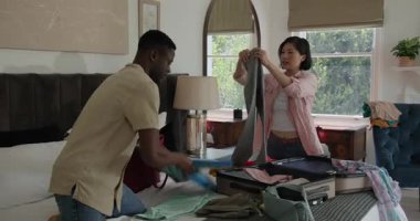 Çeşitli çiftler bavullarını açıyor ve yatak odasında çeşitli giysileri sınıflandırıyor. Yolculuğa hazırlanıyorlar. İşbirliği, organizasyon, yaşam tarzı, yerli, takım çalışması, minimalizm, uyum