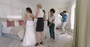 Çeşitli gelin partileri dantelli elbiseyi ayarlıyor. Fotoğrafçı yatak odasına giriyor ve test ediyor. Zarafet, kutlama, moda, kadınlık, iç mekan, işçilik, detay