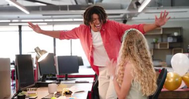 Doğum günü kutlamaları erkek iş arkadaşının ofise girmesi ve kadın iş arkadaşına pasta götürmesi. Kutlama, takım çalışması, neşeli, modern, üretkenlik, ofis, yoldaşlık