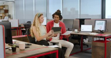 Modern ofiste iş birliği yapan, kağıtları inceleyen ve tabletin yanında gülümseyen çeşitli iş arkadaşları. Çalışma alanı, işbirliği, takım çalışması, üretkenlik, profesyonellik, çoklu görev, modern