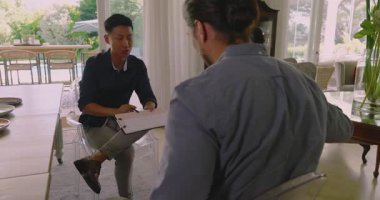 Yemek masasında karşılayan çift, Asyalı tasarımcı skeçleri gösteriyor ve anlaşmayı sonuçlandırıyor. Profesyonel, işbirliği, iç mimari, gayrimenkul, müzakere, modern