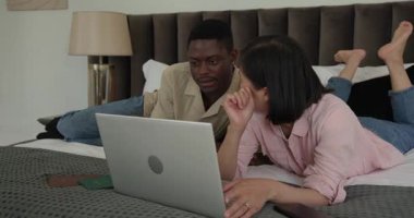 Yataktaki çeşitli çiftler dizüstü bilgisayara bakıp ekip çalışması yapıyor, tableti işaret ediyor ve akıllı telefonu paylaşıyorlar. İşbirliği, takım çalışması, teknoloji, iletişim, gündelik, samimiyet, modern