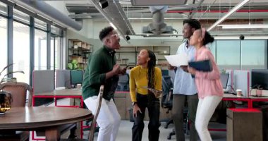 Afrika kökenli Amerikalı meslektaşlar modern ofisteki ekip üyelerini tablet ve kağıtlarla tebrik ediyor. Kutlama, takım çalışması, işbirliği, ofis, başarı, motivasyon, verimlilik