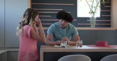 Genç çift mutfak tezgahında planlarını tartışıyor, gülümsüyor ve evdeki sohbetin tadını çıkarıyor. communication, relationship, planlama, interaction, happiness