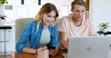 Çift evde dizüstü bilgisayar ve akıllı telefon kullanıyor, kahve içerken planları tartışıyorlar. Teknoloji, tartışma, planlama, iletişim, yaşam tarzı, gelişigüzel