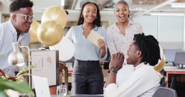 Afro-Amerikalı iş arkadaşları açık ofiste zarf açılışını kutluyorlar. Haritalarla, fotokopi alanlarıyla. Takım çalışması, işbirliği, sürpriz, heyecan, kilometre taşı, başarı, çalışma alanı