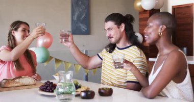 Sıradan bir toplantı sırasında yemek masasında arkadaşlarıyla konuşan Afro-Amerikalı bir kadın. sohbet, sosyalleşme, çok kültürlü, kutlama, topluluk, arkadaşlık