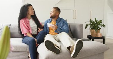 Afrikalı Amerikalı bir çift kanepeyi tutarken parmak izlerini inceliyor, gülümsüyor, işaret ediyor, sarılıyor. Samimiyet, şefkat, şefkat, arkadaşlık, rahat, modern, yaşam tarzı.