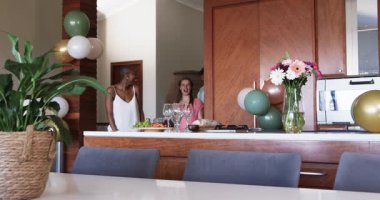 Arkadaşlar modern mutfakta toplanır, sohbet eder, abur cubur ve içeceklerin tadını çıkarırlar. Arkadaşlık, sosyalleşme, sohbet, boş zaman