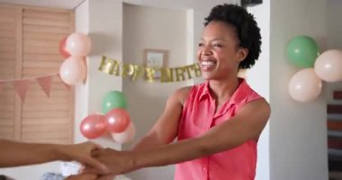 Çeşitli kadın çiftler doğum günü kutlaması sırasında balonlarla evde sevinçle kucaklaşıyorlar. Aşk, ilişki, birliktelik, parti, sürpriz, mutluluk