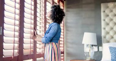 Afro-Amerikalı kadınlar yatakta oturuyor, gülümsüyor ve evde konuşuyorlar. Yaşam tarzı, arkadaşlık, sohbet, mutluluk, bağlanma, boş zaman