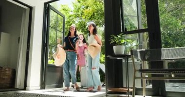 Geniş cam kapılar, çeşitli bayan arkadaşlar eve giriyor kucaklaşıp bavulu çekiyorlar. Seremoni, yaşam tarzı, minimalist, seyahat, boş zaman, canlı, açık hava