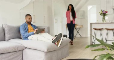 Çeşitli çiftler oturma odasında birbirlerine sarılmadan önce tablet okuyan bir adamla hediye paylaşıyorlar. Samimiyet, samimiyet, sıcaklık, bağlantı, konfor, modern yaşam tarzı