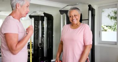 Üst düzey kadınlar spor salonunda bel ölçülerini sarı bantla ölçüp fitness hedeflerine ulaşıyorlar. Fitness, arkadaşlık, destek, motivasyon, sağlıklı, egzersiz, sağlık