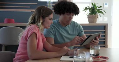 Evde tablet ve kredi kartı kullanan ve online alışveriş yapmayı planlayan genç bir çift. E-ticaret, alışveriş, teknoloji, kolaylık, finans, işlem