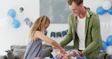 Baba ve kızı konfetileri poşetlere süpürüyor, fincanları fırlatıyor ve evde parti üstüne kucak paylaşıyorlar. Kutlama, aile, neşeli, neşeli, evcil, samimi, samimi