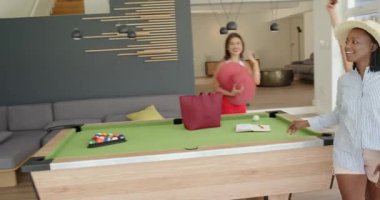 Çeşitli arkadaşlar tatil için kiralanmış evlere geliyorlar, ellerinde kırmızı havlu ve renkli havlular var. Tatil, arkadaşlık, varış, kutlama, eğlence, tarz, sıcak