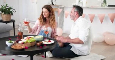 Oturma odasındaki yastıklarda oturan yaşlı çifti yudumladıktan, yüzüklerini takıp sarıldıktan sonra. Romantik, kutlama, samimiyet, neşe, zarafet, yaşam tarzı, rahatlık.