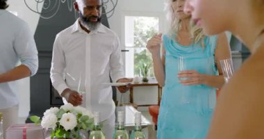 Çeşitli arkadaşlar oturma odasında toplanıp resepsiyon için flüt ve aperatif seçiyorlar. Kutlama, sosyalleşme, zarafet, samimiyet, konukseverlik, dekor, eğlence