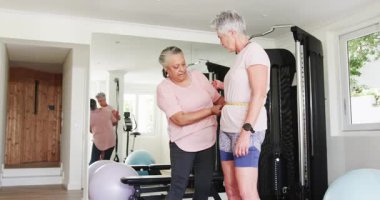 Kıdemli kadınlar spor salonunda çalışan çeşitli bayan arkadaşlar, mezura ve jimnastik aletleri kullanıyorlar. Fitness, arkadaşlık, sağlık, takım çalışması, egzersiz, motivasyon, sağlık