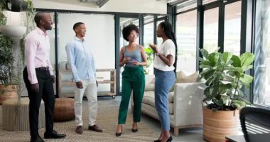 Çeşitli meslektaşlar modern salonda ofis bitkileri, kanepe ve sehpa ile samimi sohbetler yapıyorlar. Ağ oluşturma, işbirliği, profesyonellik, katılım, yoldaşlık, modern, çalışma alanı