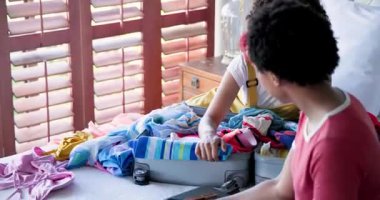 Ortağıyla birlikte evde bavul hazırlayan gülümseyen kadın, tatile hazırlanıyor. Seyahat, lezbiyen çift, planlama, kaçamak, boş zaman