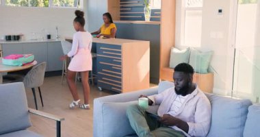 Afro-Amerikan aile evde okula hazırlanıyor, anne meyve suyu veriyor, baba kayışları ayarlıyor. Aile, ebeveynlik, aile hayatı, yaşam tarzı, sabah rutini, rahat, etkileşim