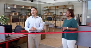 Çağdaş ofiste kurdele kesme anını kutlayan çeşitli iş arkadaşları, neşeli ruhun tadını çıkarıyorlar. Kutlama, takım çalışması, başarı, coşku, ofis, iç mekan, şirket